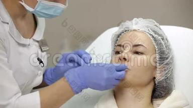 美容师在隆唇手术前将麻醉膏涂于病人嘴唇上